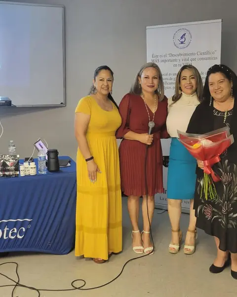Carina con su equipo en una capacitación, con productos Immunotec en la mesa